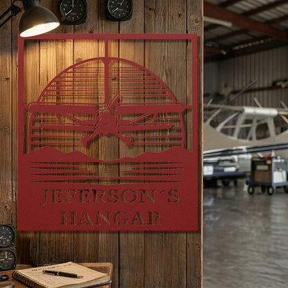 Red metal pilot hangar sign with custom family name mounted on hangar door